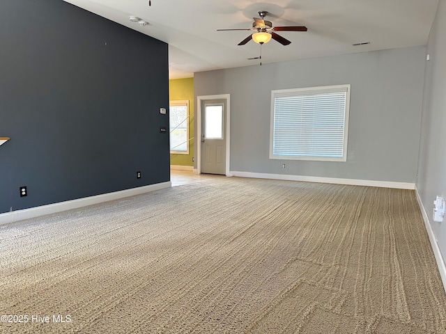 spare room with ceiling fan and light carpet