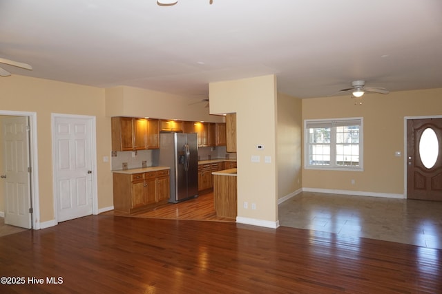 unfurnished living room with ceiling fan and dark wood-type flooring