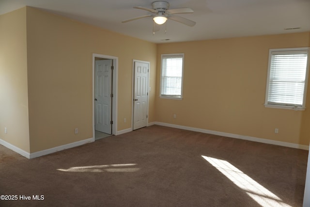 carpeted spare room with ceiling fan and plenty of natural light