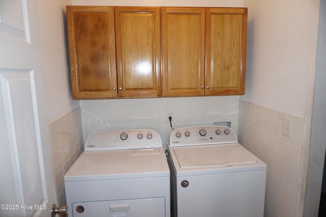 washroom featuring cabinets and washing machine and dryer