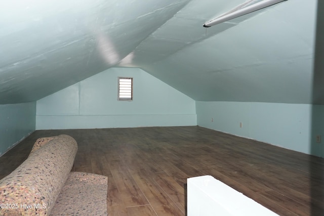 bonus room with dark hardwood / wood-style floors and vaulted ceiling