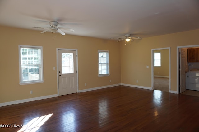 unfurnished living room featuring dark hardwood / wood-style floors, ceiling fan, and washer / clothes dryer