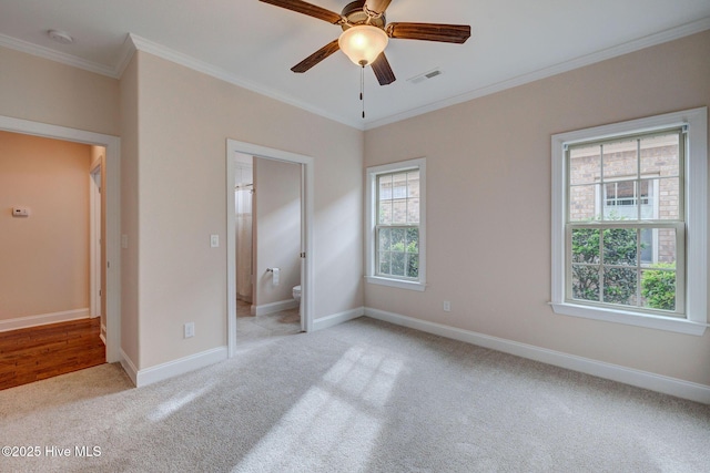 unfurnished bedroom with ceiling fan, light colored carpet, ornamental molding, and connected bathroom