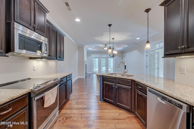 kitchen featuring sink, french doors, stainless steel appliances, crown molding, and pendant lighting