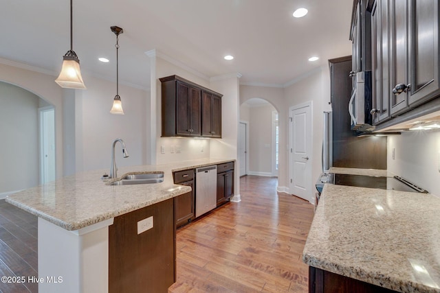 kitchen featuring dishwasher, sink, hanging light fixtures, ornamental molding, and light stone counters