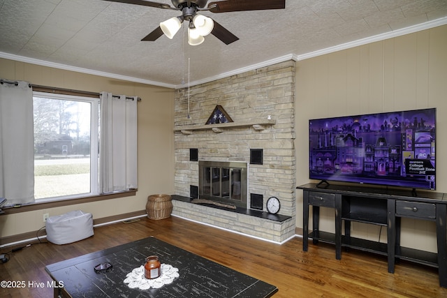 living room with hardwood / wood-style flooring, ornamental molding, a fireplace, and a textured ceiling