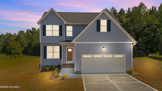 view of front of home featuring a garage and a yard