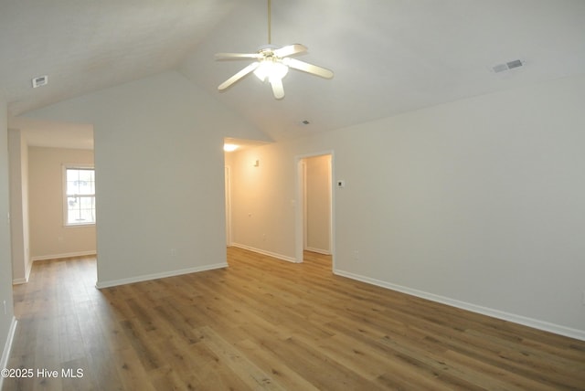 spare room with hardwood / wood-style floors, vaulted ceiling, and ceiling fan