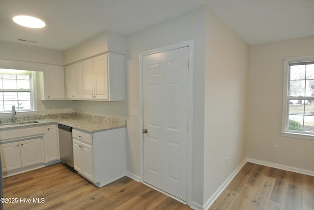 kitchen with dishwasher, sink, white cabinets, and light wood-type flooring