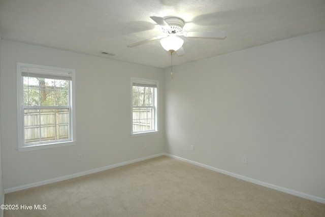 carpeted empty room with a textured ceiling and ceiling fan