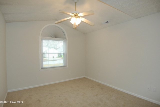 carpeted spare room with vaulted ceiling and ceiling fan