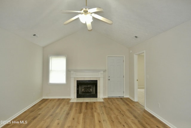 unfurnished living room with vaulted ceiling, ceiling fan, a fireplace, and light hardwood / wood-style floors