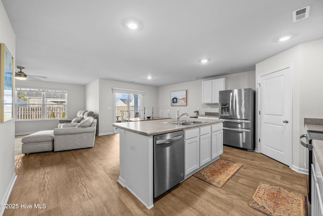 kitchen featuring a kitchen island with sink, sink, white cabinets, and stainless steel appliances