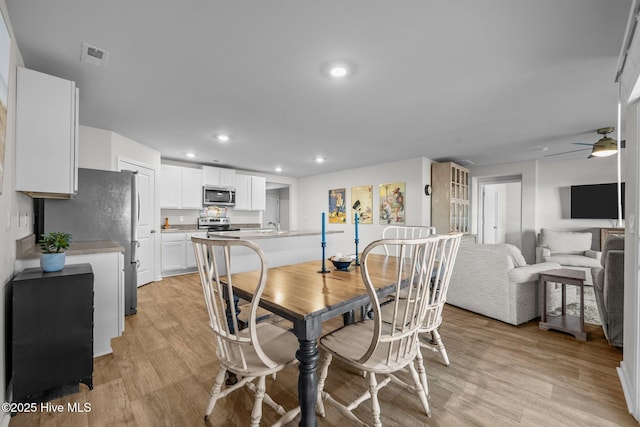 dining area with ceiling fan and light hardwood / wood-style floors