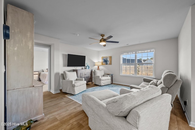 living room featuring ceiling fan and light hardwood / wood-style flooring