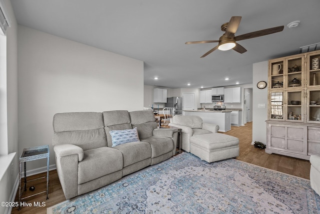 living room with ceiling fan and light hardwood / wood-style flooring