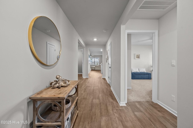 corridor with light hardwood / wood-style floors