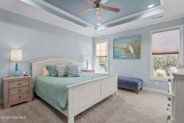 bedroom featuring a tray ceiling, multiple windows, ceiling fan, and crown molding