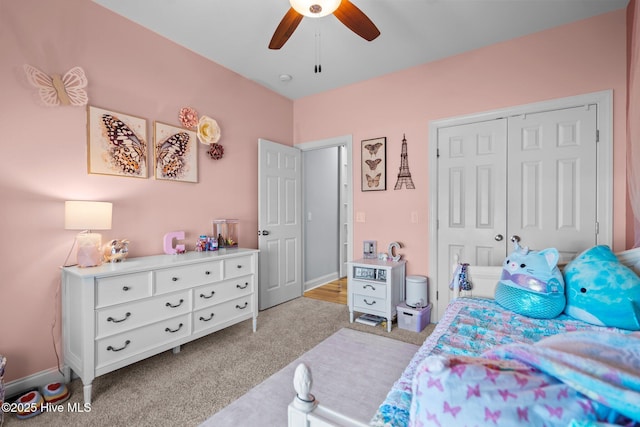 bedroom featuring ceiling fan, light carpet, and a closet