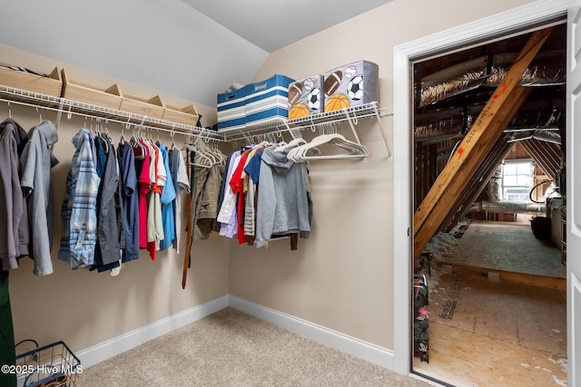 walk in closet with carpet floors and vaulted ceiling