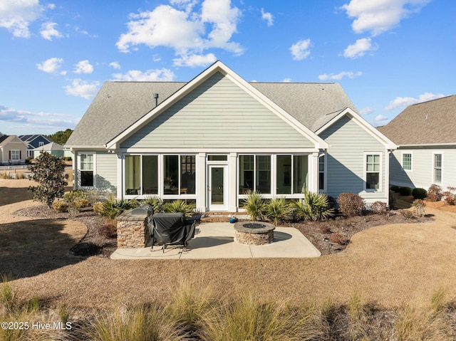 back of property with a fire pit and a patio