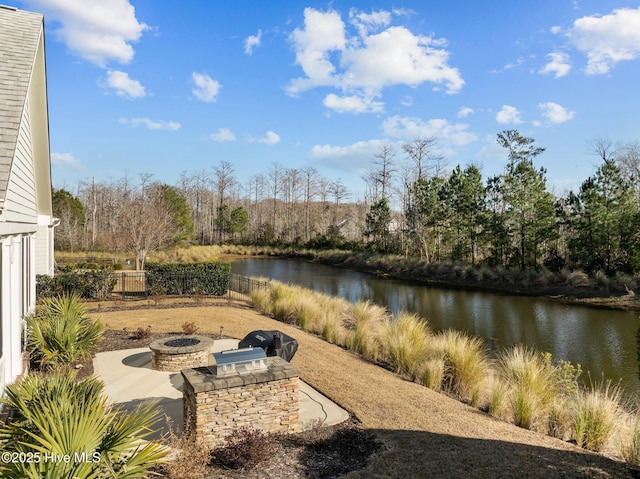 view of patio with a water view and a fire pit