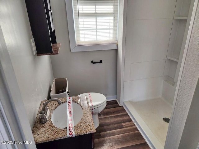 bathroom featuring hardwood / wood-style floors, vanity, toilet, and walk in shower