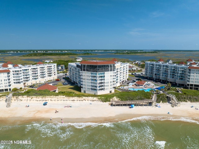 birds eye view of property with a water view and a beach view