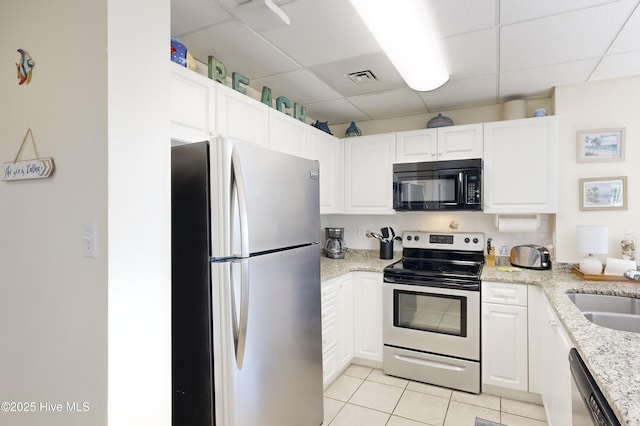 kitchen featuring light stone countertops, light tile patterned floors, stainless steel appliances, and white cabinetry