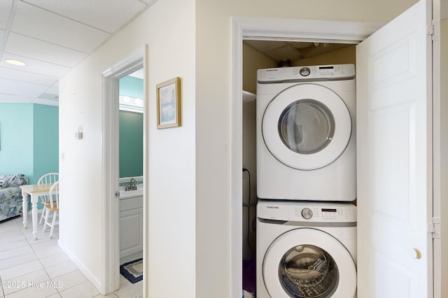 washroom with stacked washing maching and dryer and light tile patterned floors