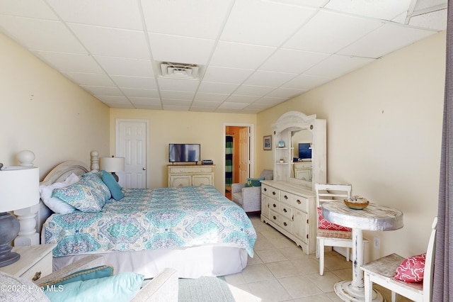 bedroom with a paneled ceiling and light tile patterned floors