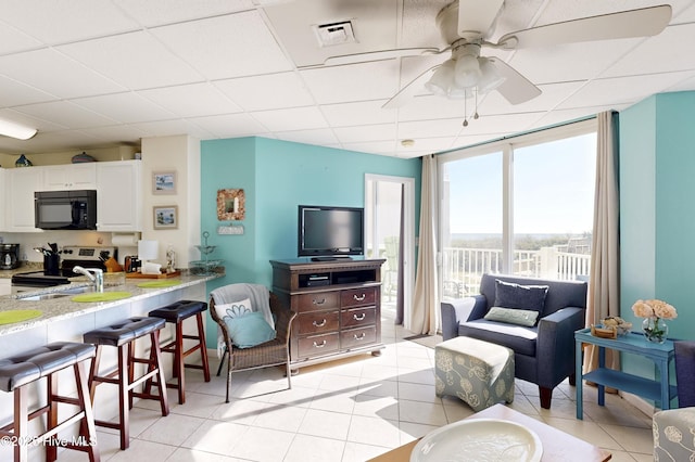 tiled living room with a drop ceiling and sink