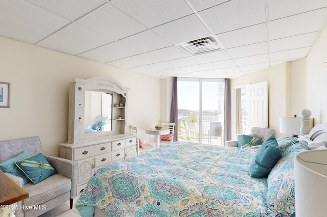 bedroom featuring a paneled ceiling and a wall of windows