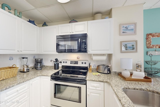 kitchen with white cabinetry, electric range, and a drop ceiling