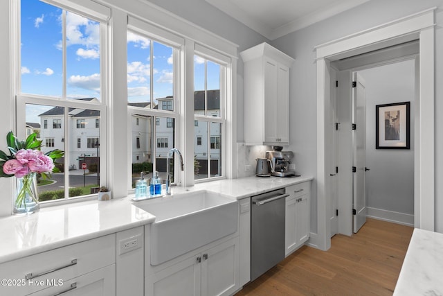 kitchen featuring sink, white cabinetry, tasteful backsplash, light wood-type flooring, and dishwasher