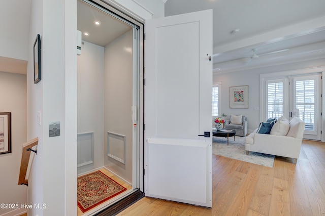 interior space with beamed ceiling and light hardwood / wood-style floors