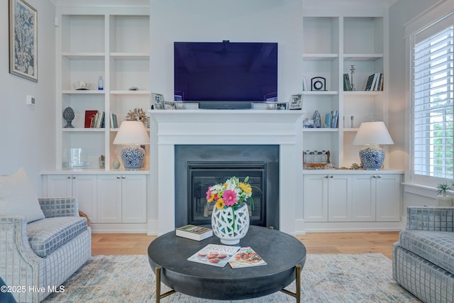 living room featuring light hardwood / wood-style flooring and built in features