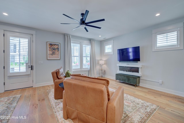 living room featuring ceiling fan and light hardwood / wood-style flooring