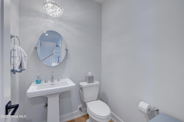 bathroom featuring a chandelier and toilet