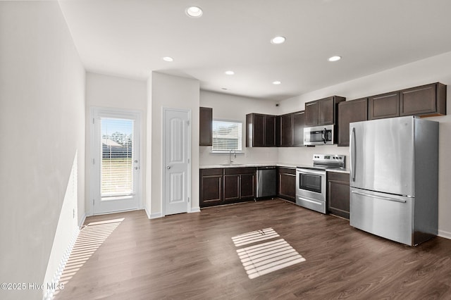 kitchen with dark hardwood / wood-style flooring, sink, dark brown cabinetry, and stainless steel appliances