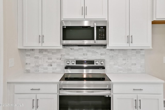 kitchen with stainless steel appliances, white cabinetry, and tasteful backsplash