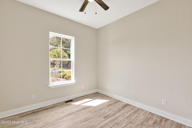 spare room with ceiling fan, baseboards, visible vents, and light wood-style flooring