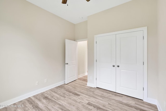 unfurnished bedroom with light hardwood / wood-style floors, a closet, and ceiling fan