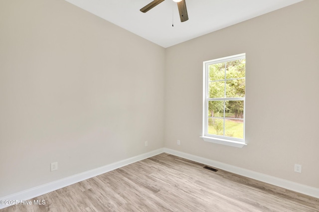 spare room with light wood-style floors, a ceiling fan, and baseboards