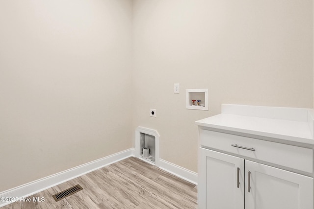 laundry area with hookup for an electric dryer, cabinets, light wood-type flooring, and hookup for a washing machine