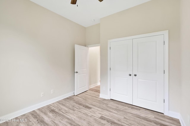 unfurnished bedroom with light wood-type flooring, baseboards, a closet, and ceiling fan