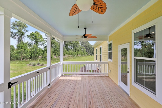 wooden deck featuring a yard and a ceiling fan