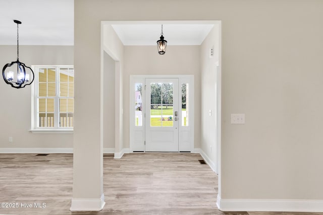 foyer with light wood-type flooring and a notable chandelier