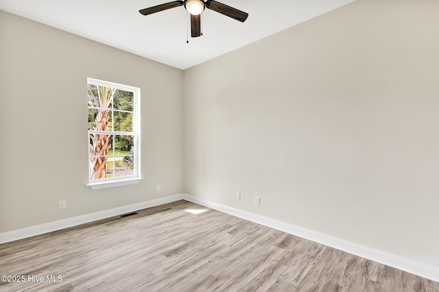 unfurnished room featuring baseboards, a ceiling fan, visible vents, and light wood-type flooring