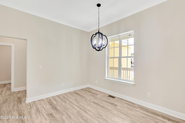 unfurnished dining area with light wood-style flooring, visible vents, baseboards, and a notable chandelier